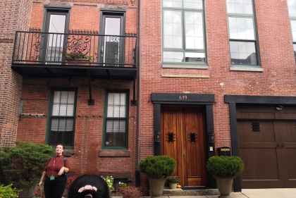 Person speaking in front of brick rowhouses