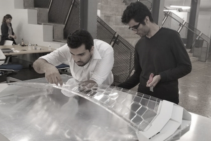 Two people working on a complex architectural model 