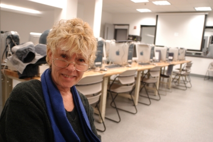 Becky Young seated in a classroom with computers behind her