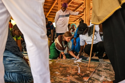 Group of people gathered around map on the ground