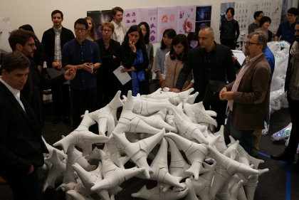 Group gathered around a sculpture that resembles a pile of bones