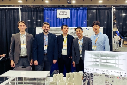 Project team at the summit, in front of models of the concrete structure