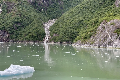 Rocky shoreline with scrub and icy valley seen from the water