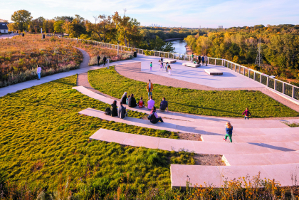 Fingers of concrete benches on grassy park overlooking river