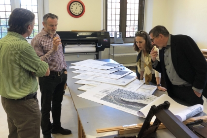 The Gonicks and two Weitzman faculty are gathered around a table with archival documents