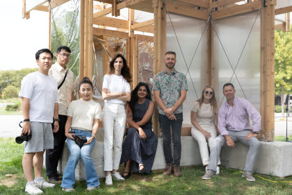 Group of people standing outdoors next to wood pavilion