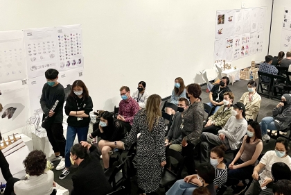 Students gathered in the Plaza Gallery at Meyerson Hall with their work pinned to the walls for review/discussion.