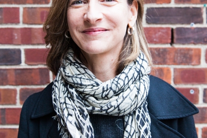 Marion Weiss smiling in front of brick wall.