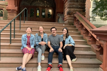 Four members of PPSA sitting and smiling on the steps of Fisher