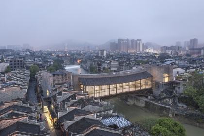 Illuminated lantern-like bridge in dense low-rise Chinese city neighborhood