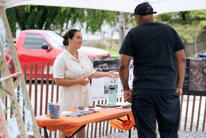 Woman speaks to man at outdoor table