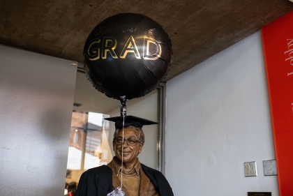 Stuart Weitzman statue wearing cap and gown holding balloon