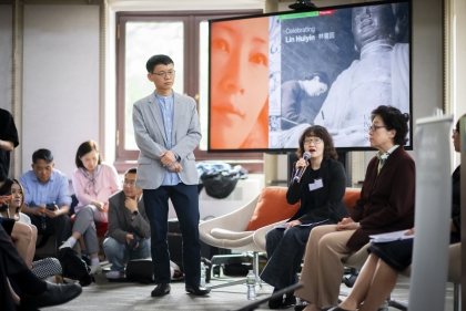 Zhongjie Lin stands in front of panelists at lecture