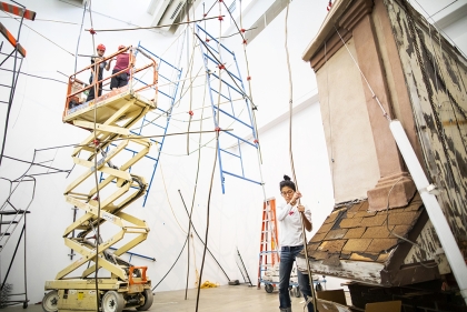 Michelle Lopez stands in the white-walled galleries at the ICA, a scissor life in the background