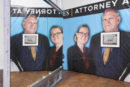 Billboard with four heads behind two framed artworks