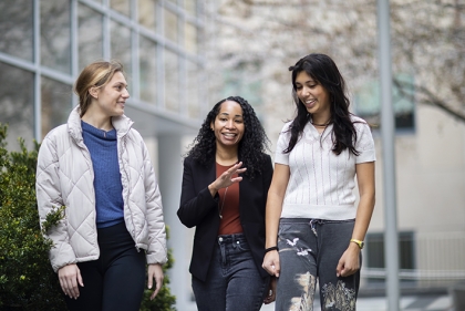 Three people walking and talking outdoors