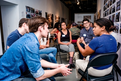 A multi-ethnic group of people seated in a circle conversation.