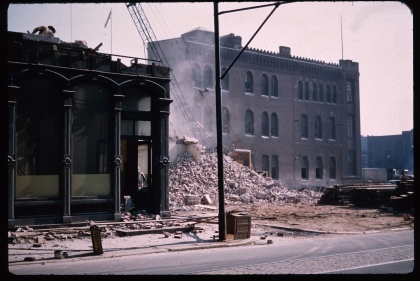 Building rubble piled up on a vacant city lot between two historic buildings