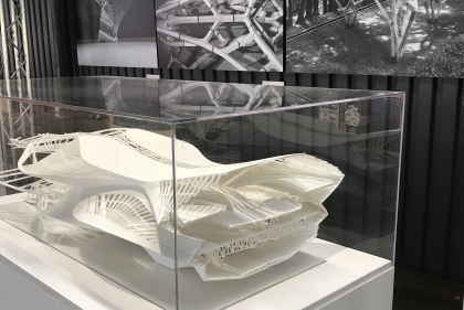 Architectural model in acrylic case with images on the wall behind