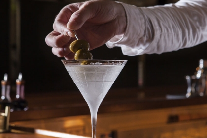 Hand stirring martini glass