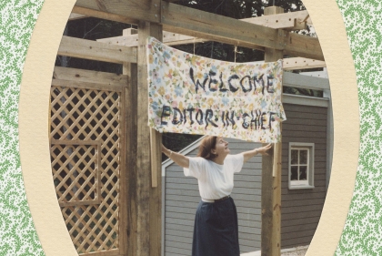 Woman holding sign saying "Welcome editor in chief"