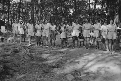 A group of women dressed in white uniforms pose for a 1934 photograph.