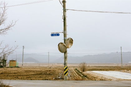 Power line on pole with traffic mirrors in rural landscape