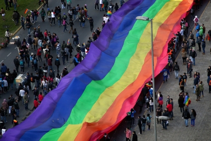 Long LGBTQ pride flag in parade