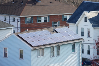 Solar panels on roof of white suburban house