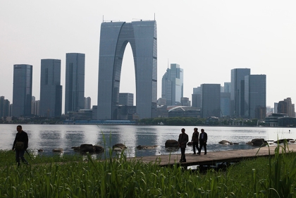 Park along a waterfront with a modern skyline on the opposite shore