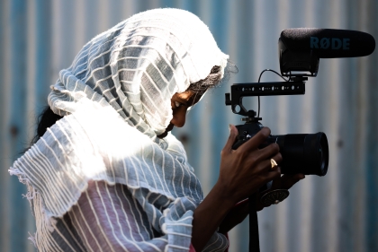 Image of lecturer Sosena Solomon filming with camera in hand.