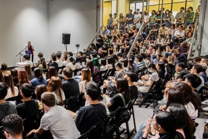 People gathered in our Plaza Gallery sitting in chairs and on the stairs for extra space.