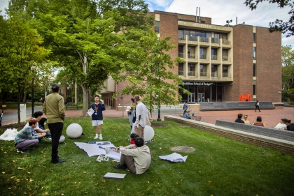 Students working on a lawn outside of Meyerson Hall