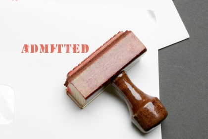 Stamped paper saying "Admitted" with stamp laying on paper.