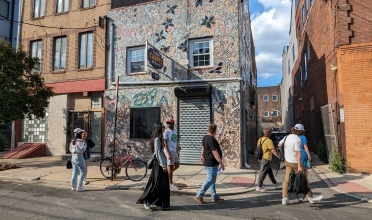 students walk in front of mosaicked rowhouse