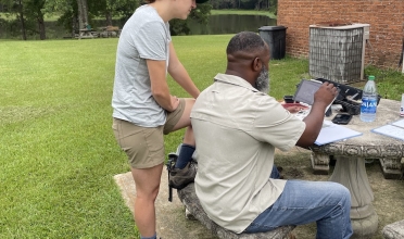 Man and woman working together outside with a drone on a table
