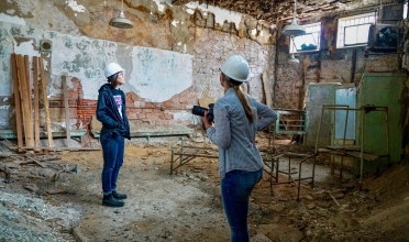 two people stand in architectural ruin