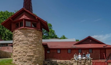 Barn connected to stone tower with steeple and weather vane