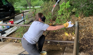 Jennifer Boggs applies hot wax to the bronze railings at Arlington National Cemetery.