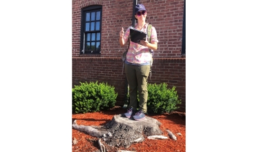 Haoyi's supervisor, Meg Frisbie, is using the arrow to record the location of the tree stump as part of the data collection proc