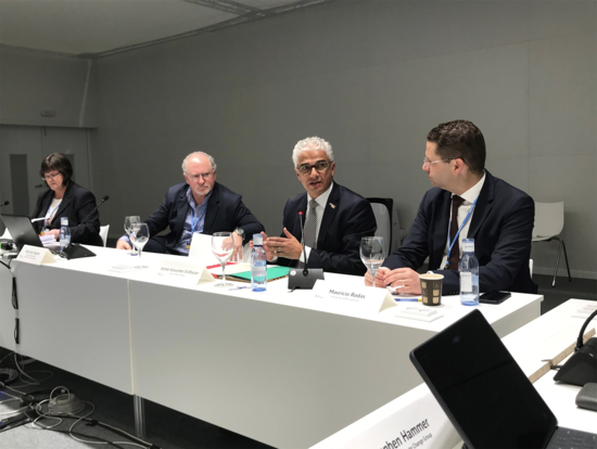 Mark Hughes seated at a panel with three other speakers