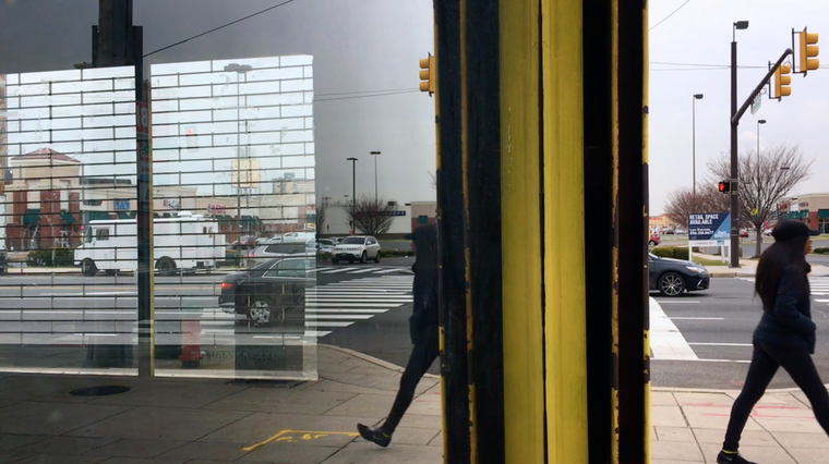 Photo of people on the street reflected in a window