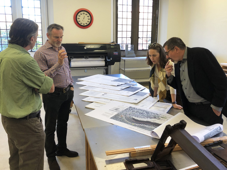 The Gonicks and two Weitzman faculty are gathered around a table with archival documents
