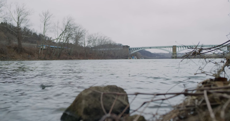 The Allegheny River, Pittsburgh Shoreline view of urban river with bridge in the distance and boulders in the foreground