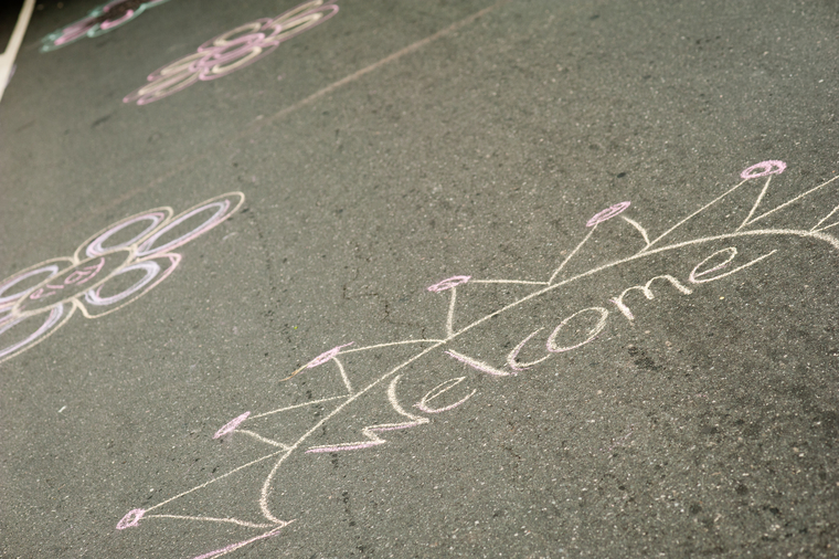 Chalk art on pavement saying "welcome"