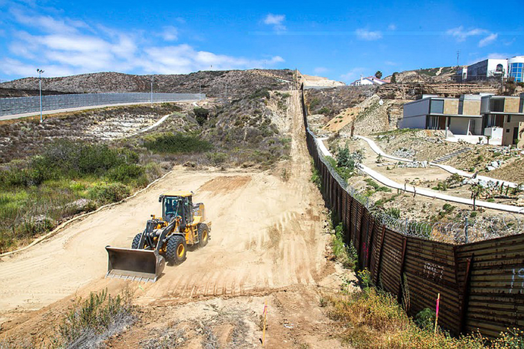 Section of border with bulldozer clearing ground