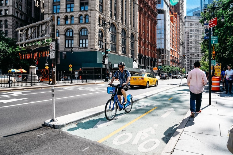 Man riding a bike through a city intersection