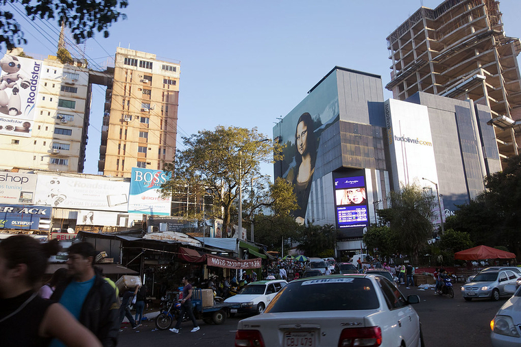 A busy urban intersection with traffic and tall buildings