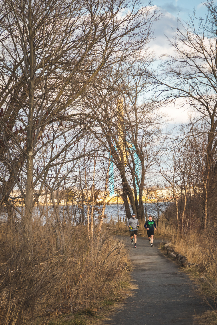 Two men jogging on a wooded path