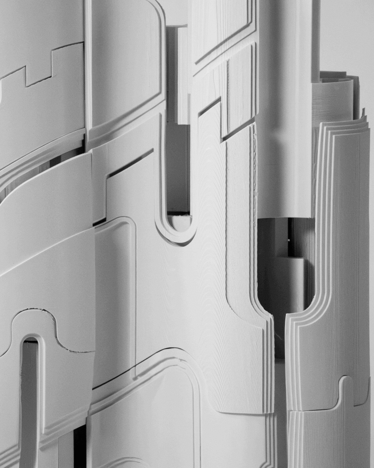 Close-up view of an architectural model showcasing layered and interlocking components. The image highlights curved and linear seams, cutouts, and partially revealed internal spaces through openings in the outer shell.